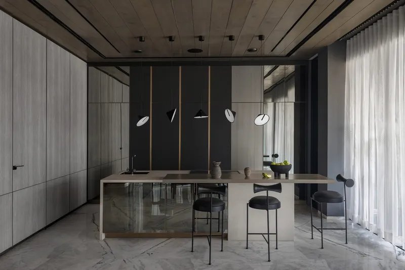 Kitchen with pale timber island, black bar stools, suspended disc pendants and concrete ceiling