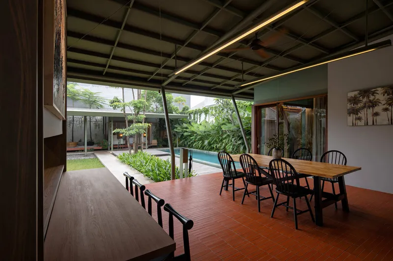 Dining area with gridded ceiling and terracotta floor tiles looking toward the garden and pool courtyard