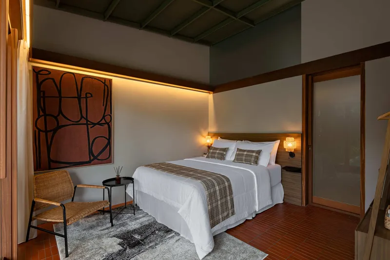 Bedroom interior with exposed coffered ceiling and timber sliding doors under warm evening lighting