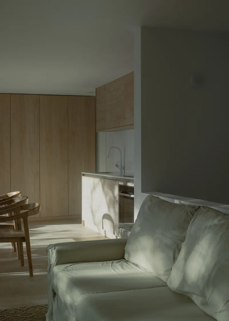Open plan interior with timber cabinetry and marbled island bathed in morning sunlight