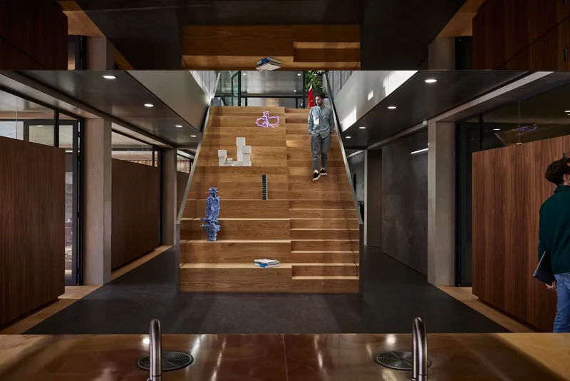 Interior staircase in timber connecting levels with a child seated on the steps