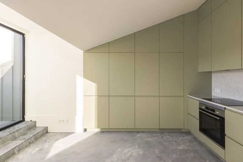 Room with full-height olive-green cabinetry and concrete floor beside granite stairs to an outdoor terrace