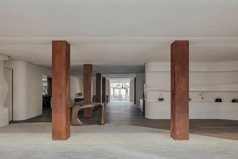 Long view through the shop interior showing a sequence of steel columns flanking the central axis
