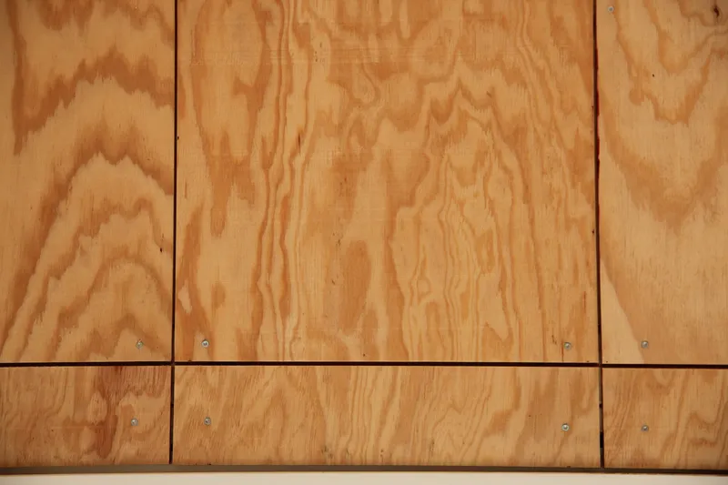 Close-up of plywood panels showing exposed grain and visible screw fasteners at seams