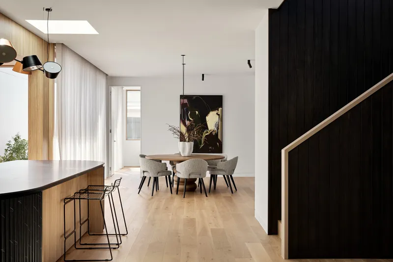 Open-plan living space with dining area and sheer curtains along the window wall
