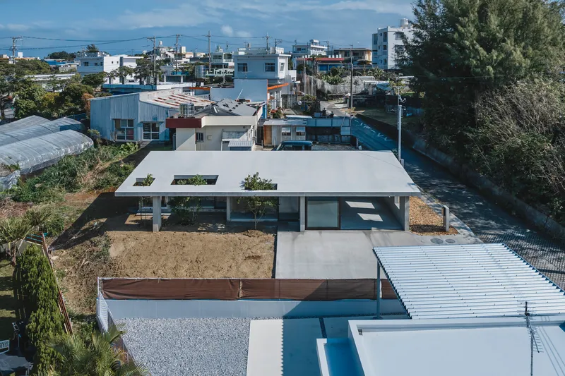 Aerial view of the concrete slab roof with planted cutouts above a residential neighborhood
