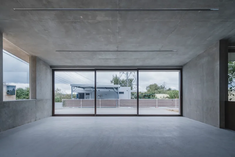 Upper level interior with panoramic sliding glass doors overlooking rooftop terrace and neighboring buildings