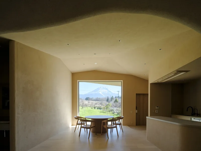 Dining area with curved plaster ceiling and picture window framing a distant snow-capped peak