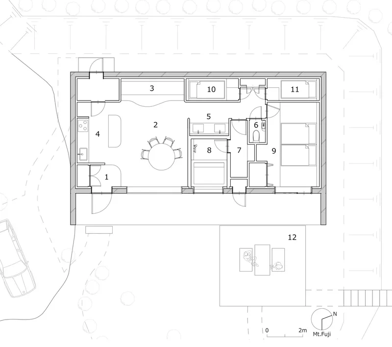 Floor plan drawing showing compact layout with central dining area and outdoor terrace
