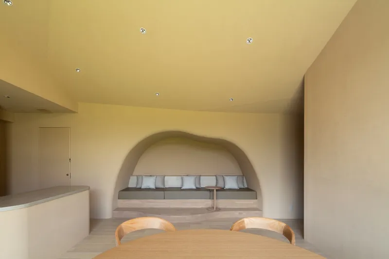Interior view of dining area with built-in bench beneath a plastered arched alcove