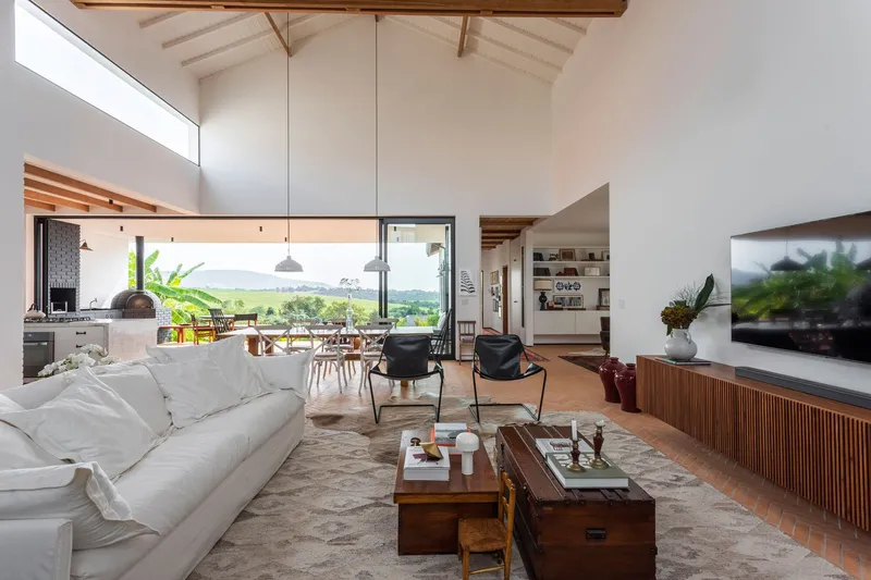 Living room with pitched ceiling, clerestory glazing and view through doors to landscape beyond