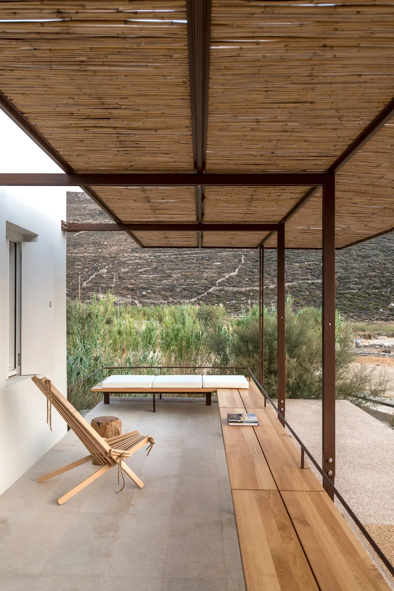 Covered terrace with slatted timber ceiling and steel frame overlooking native grasses and hillside