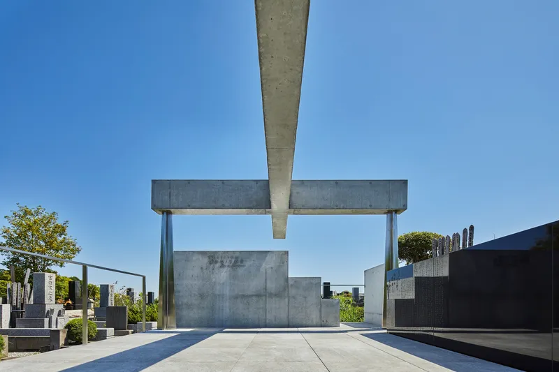 Underside view of cantilevered concrete beam meeting steel column above enclosed monument chamber