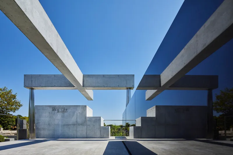 View through the intersecting concrete beam framework showing layered horizontal planes and glass partition in bright sunlight