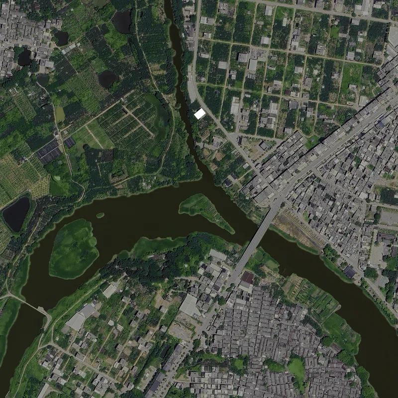 Aerial view of dense residential neighborhoods divided by a meandering river and a linear bridge