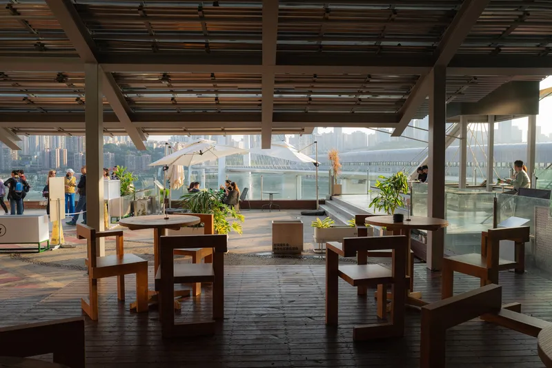 Interior dining space with timber furniture under a slatted ceiling and waterfront panorama