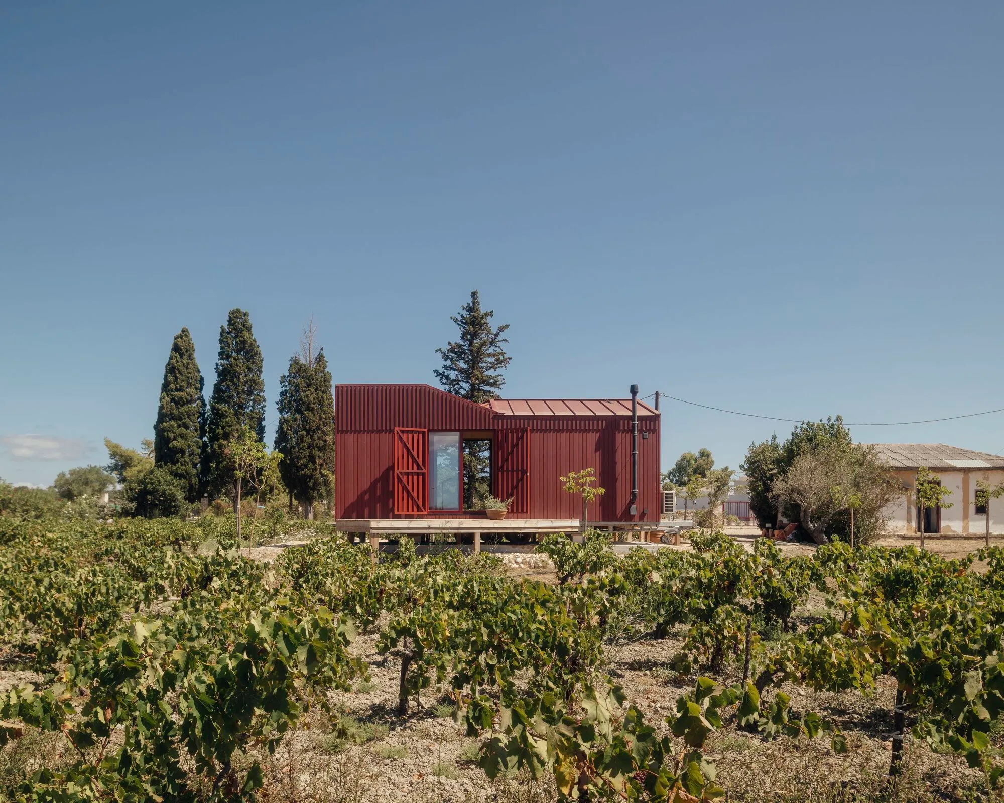 Kasawoo Plants a Deep Red Timber Cabin in a Family Vineyard on Zakynthos