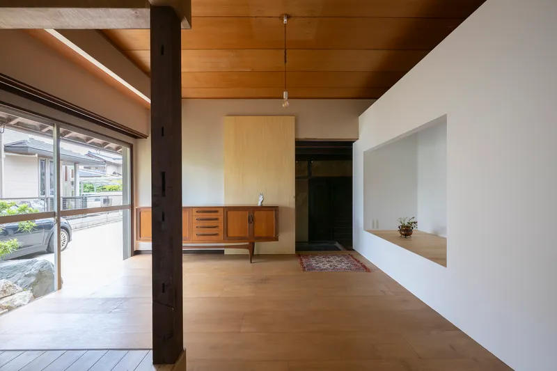Entry room with timber ceiling and vintage credenza beneath pendant light near sliding glass doors