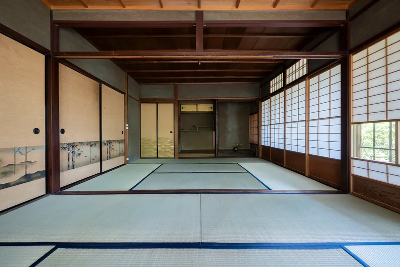 Tatami mat room with painted sliding doors and shoji screens framing adjacent interior spaces