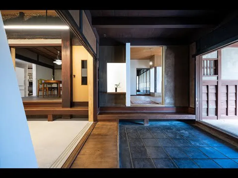 Interior courtyard with dark tile flooring surrounded by timber-framed rooms with raised wood platforms