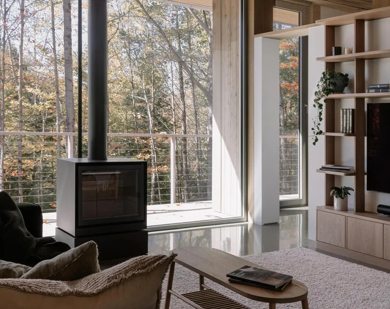 Freestanding wood stove near glazed doors opening to wooded deck