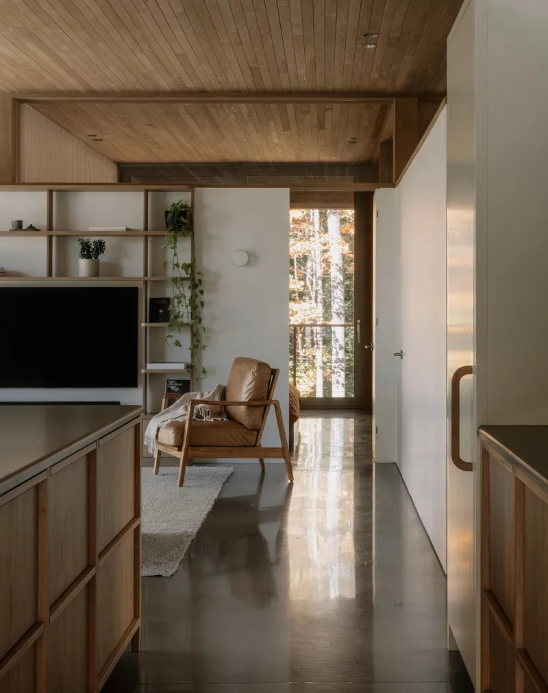 Hallway with polished concrete floor leading to seating area under coffered ceiling
