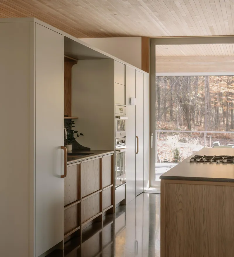 Kitchen with pale cabinetry and timber accents under a tongue-and-groove wood ceiling