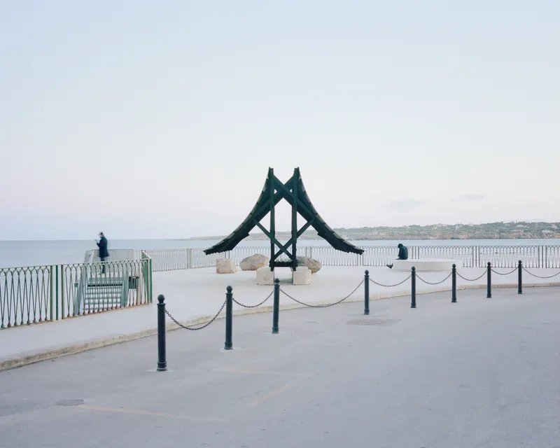 Rear view of the timber structure with A-frame supports on a plaza by the sea