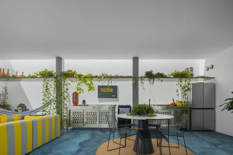 Covered living area with blue concrete floor and cascading plants along a perforated screen