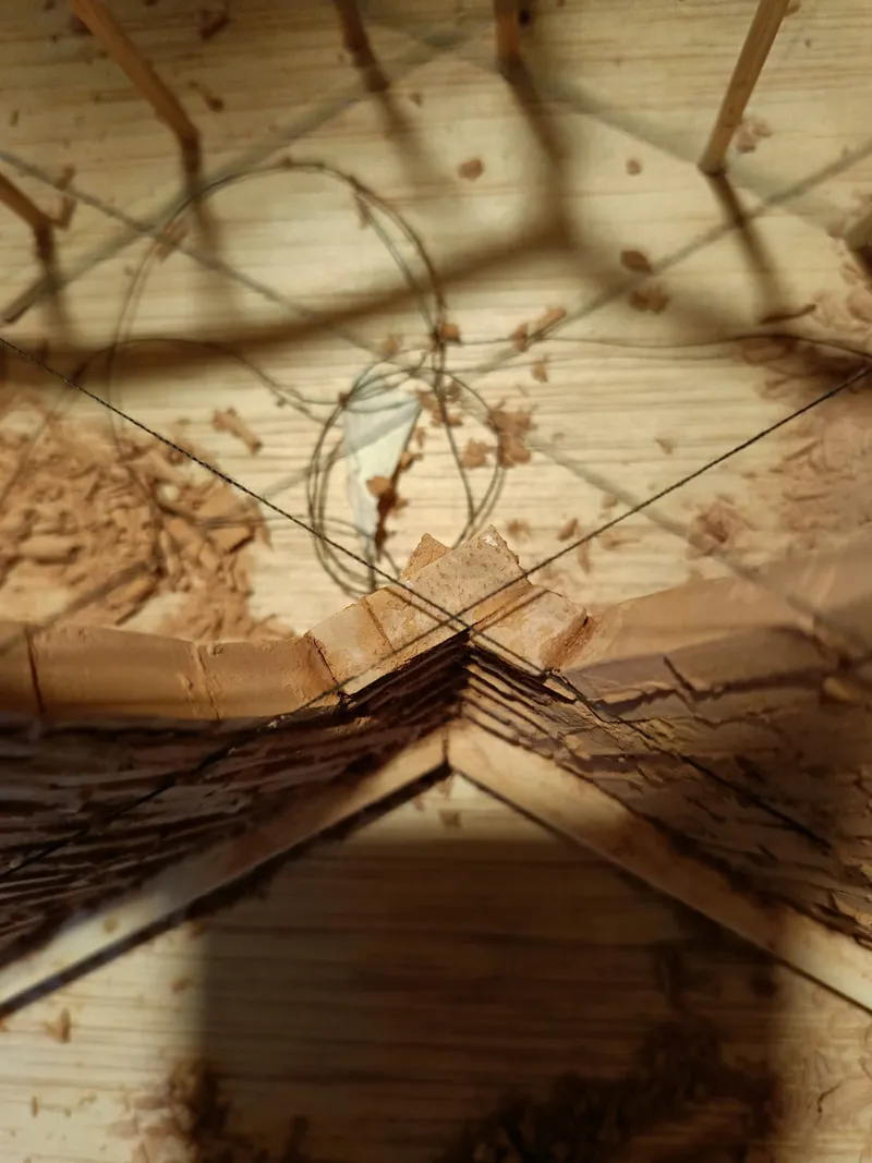 Detail of timber rib joinery at the apex showing bundled members secured with wire in physical model