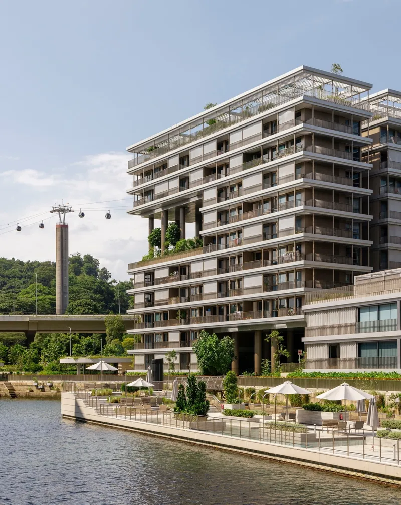 Stepped residential tower with deep balconies and rooftop gardens viewed from the waterside promenade with cable car overhead
