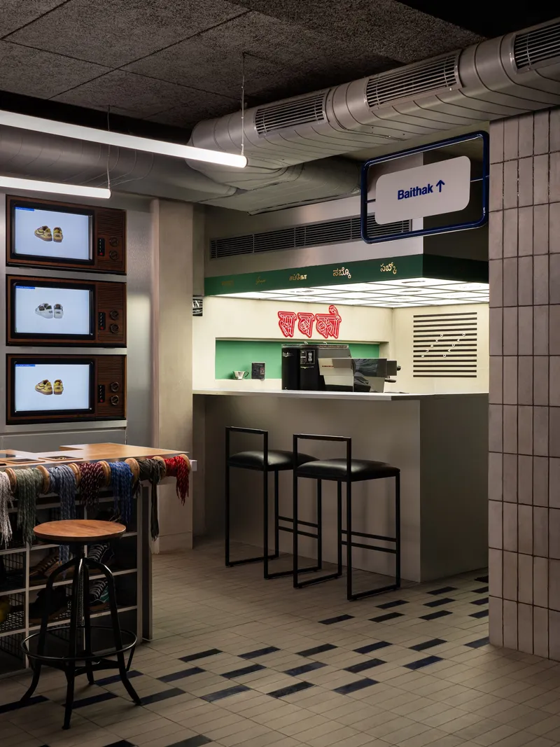 Service counter with illuminated menu panels and exposed ductwork running beneath textured ceiling tiles