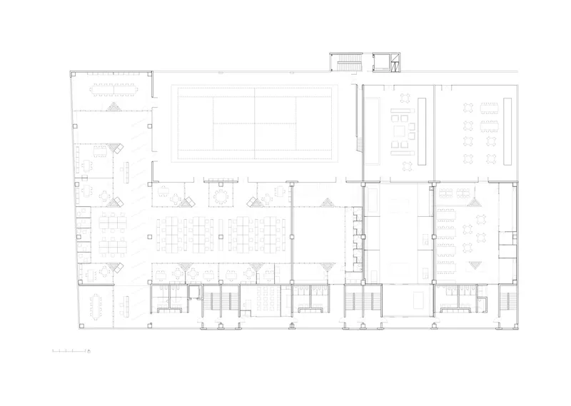 Floor plan drawing showing open work areas around central courtyard with surrounding enclosed rooms and staircases