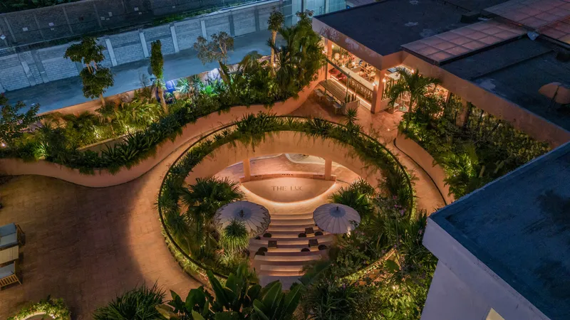 Aerial view of the circular sunken courtyard with stepped seating and planted perimeter rings at night