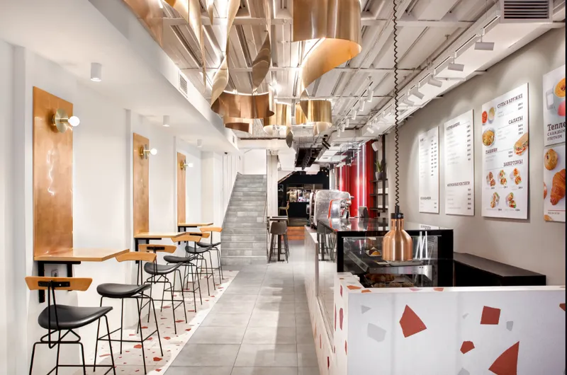 Linear layout with copper ceiling elements guiding spatial flow