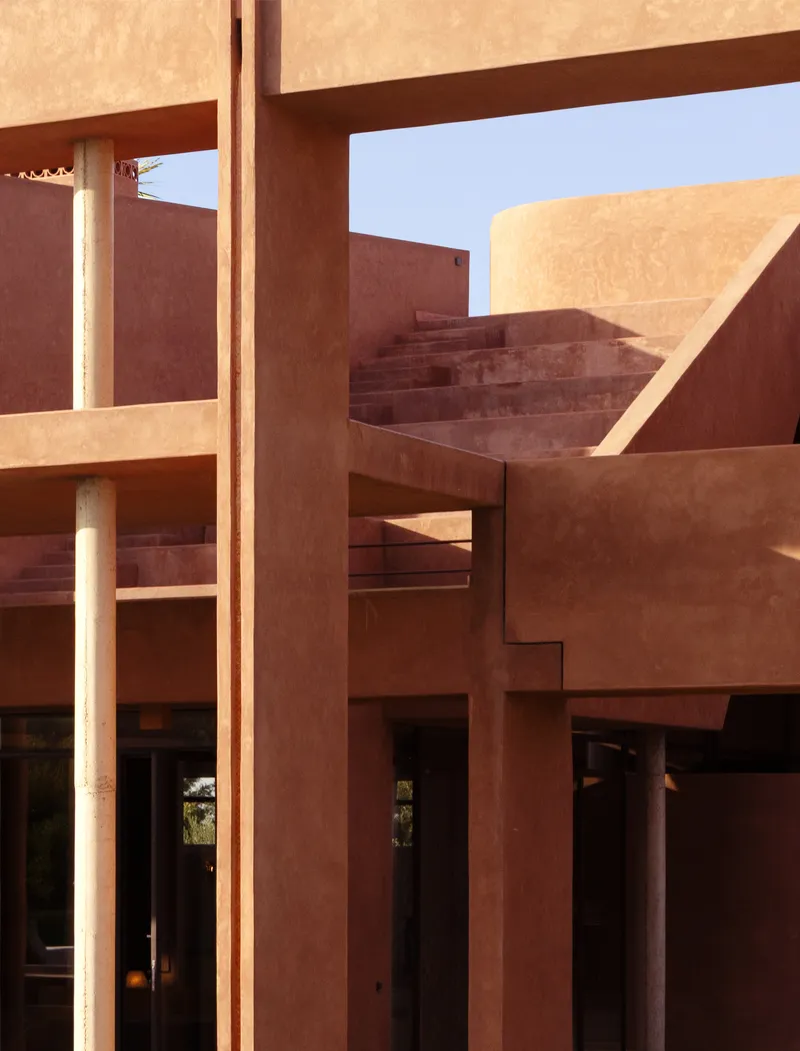 Layered terracotta stairs and beam structure framing openings in bright midday sunlight