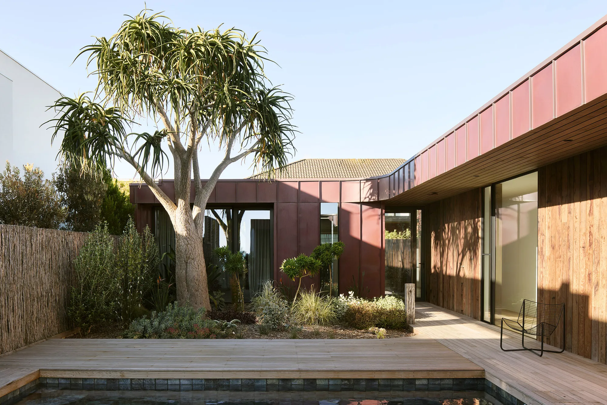 Splinter Society Wraps a Seaside Family Home in Curtains, Concrete, and Pink Steel