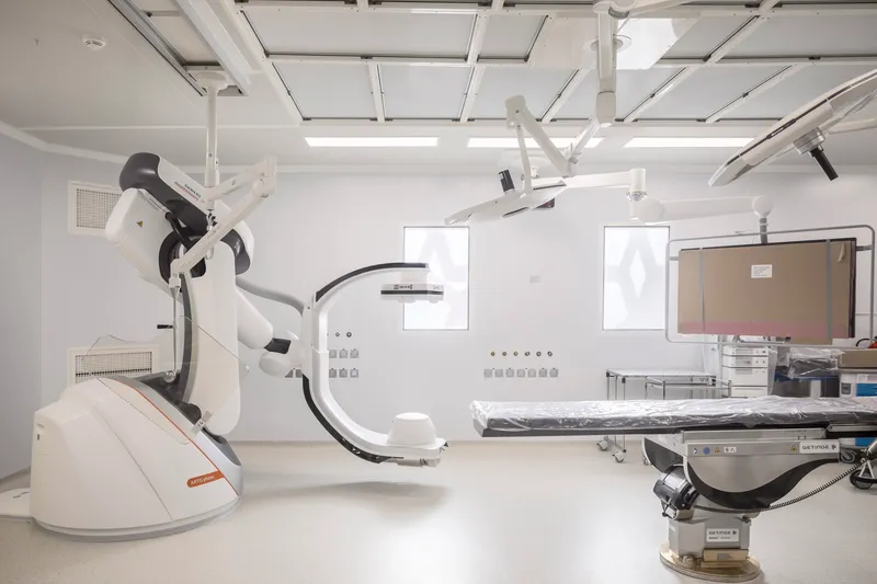 Medical imaging suite with robotic arm equipment and exposed coffered ceiling