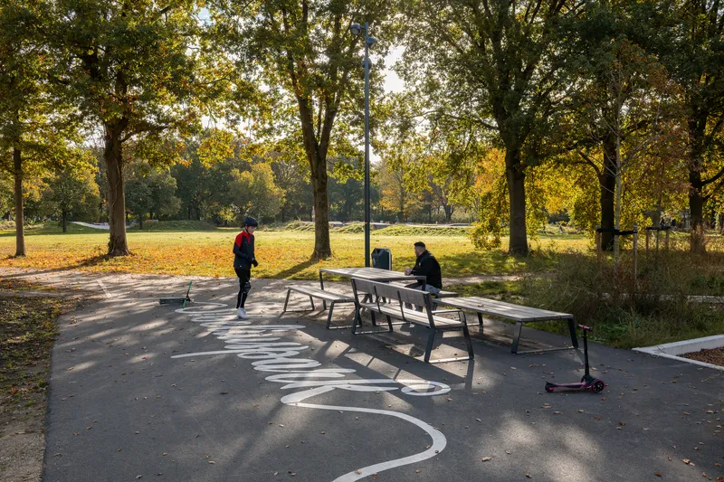Ping pong table on a curved paved court with tree shadows in autumn