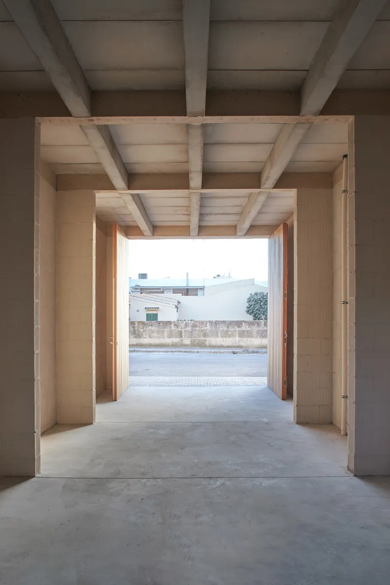 Entry passage framed by exposed timber beams and joists opening onto the street