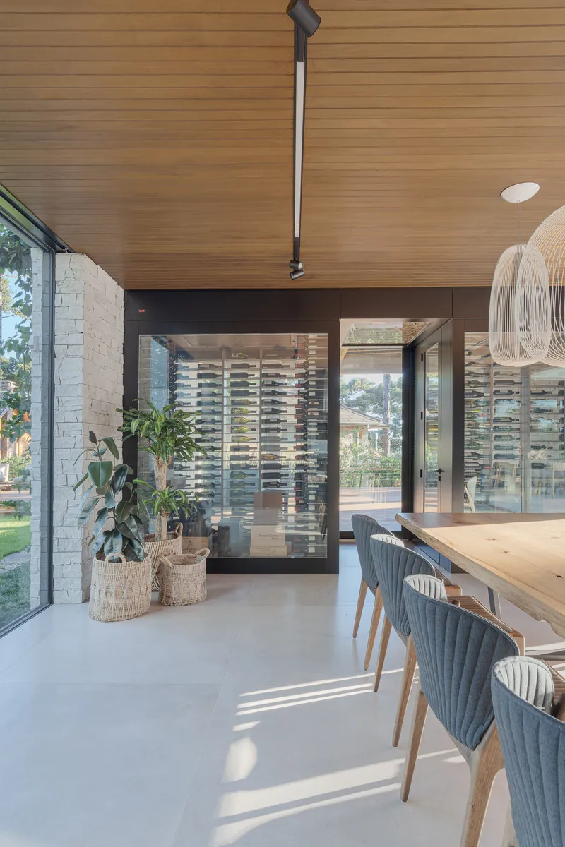 Corner threshold between interior dining area and outdoor terrace with white brick wall and potted plants