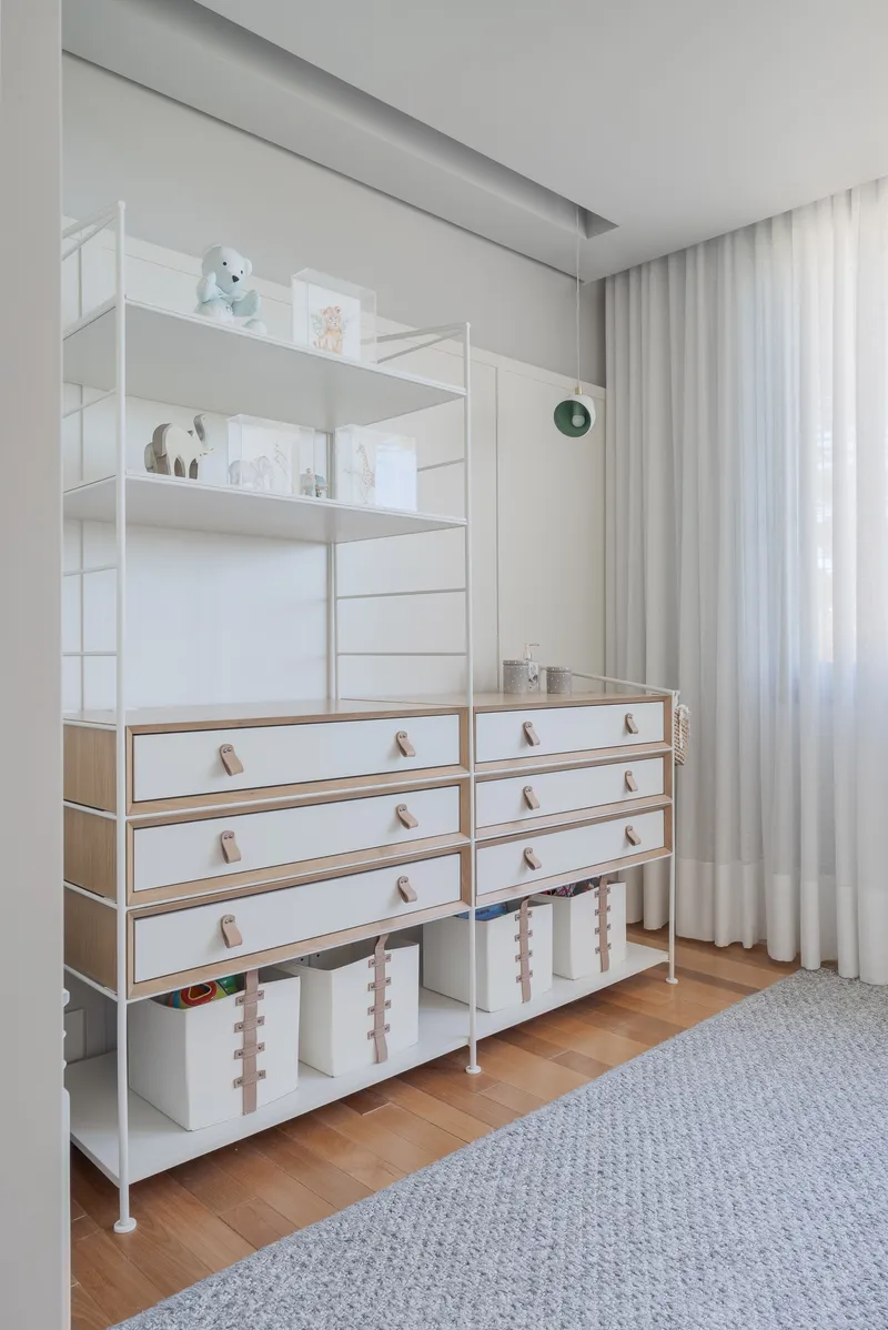 Freestanding white shelving unit with timber-edged drawers and open storage bins on wood flooring