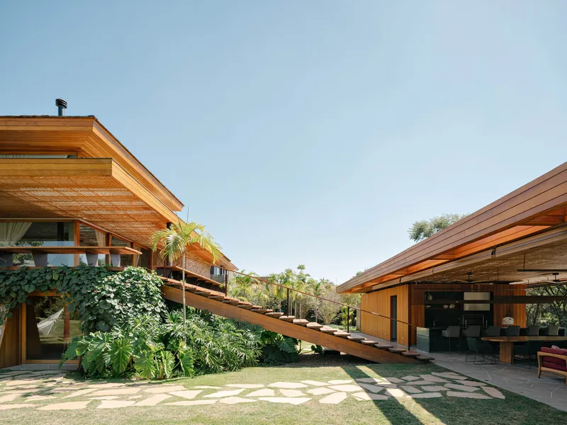 Garden courtyard view between two timber-clad volumes connected by the ascending stair