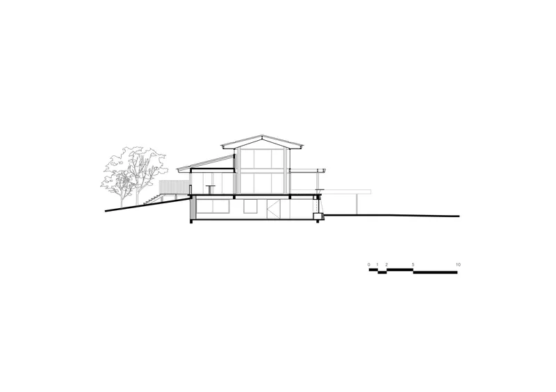 Section drawing revealing the split-level interior spaces beneath the gabled roof with clerestory glazing