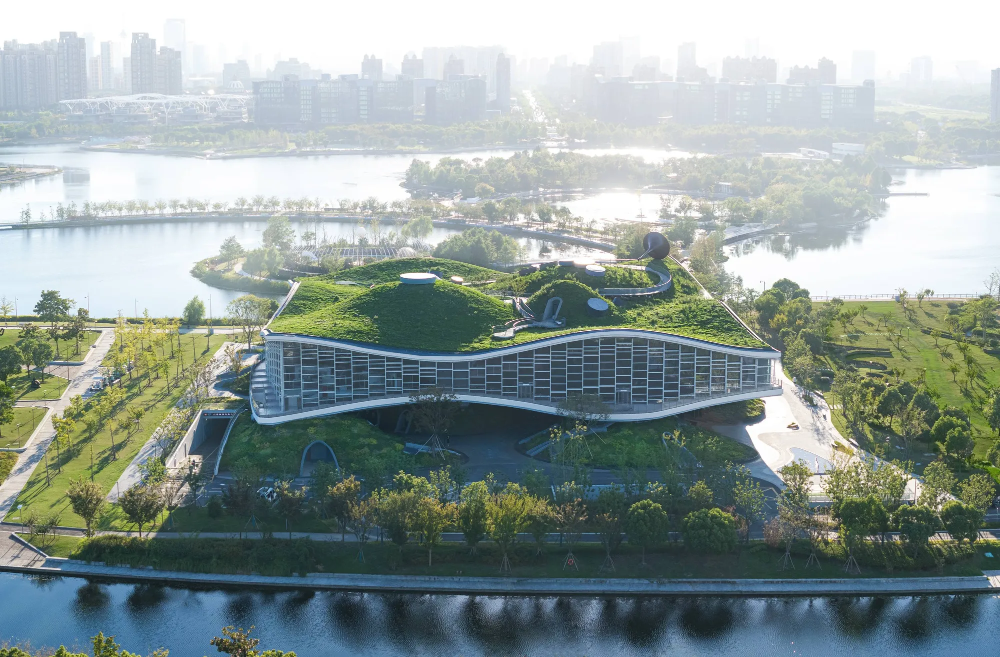 Scenic Architecture Office Sculpts a Science Fiction Museum from Concrete Waves on a Shanghai Lake