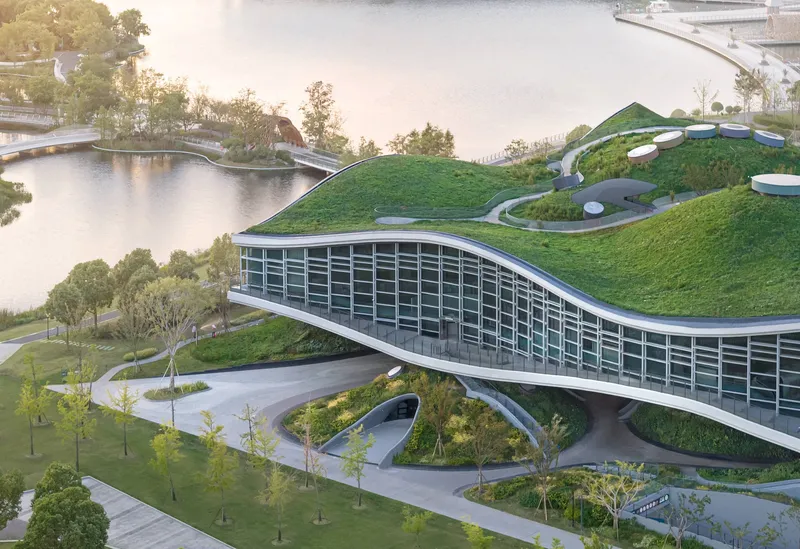 Aerial view of the grass-covered roof with circular skylights and curved pathways through the landscape