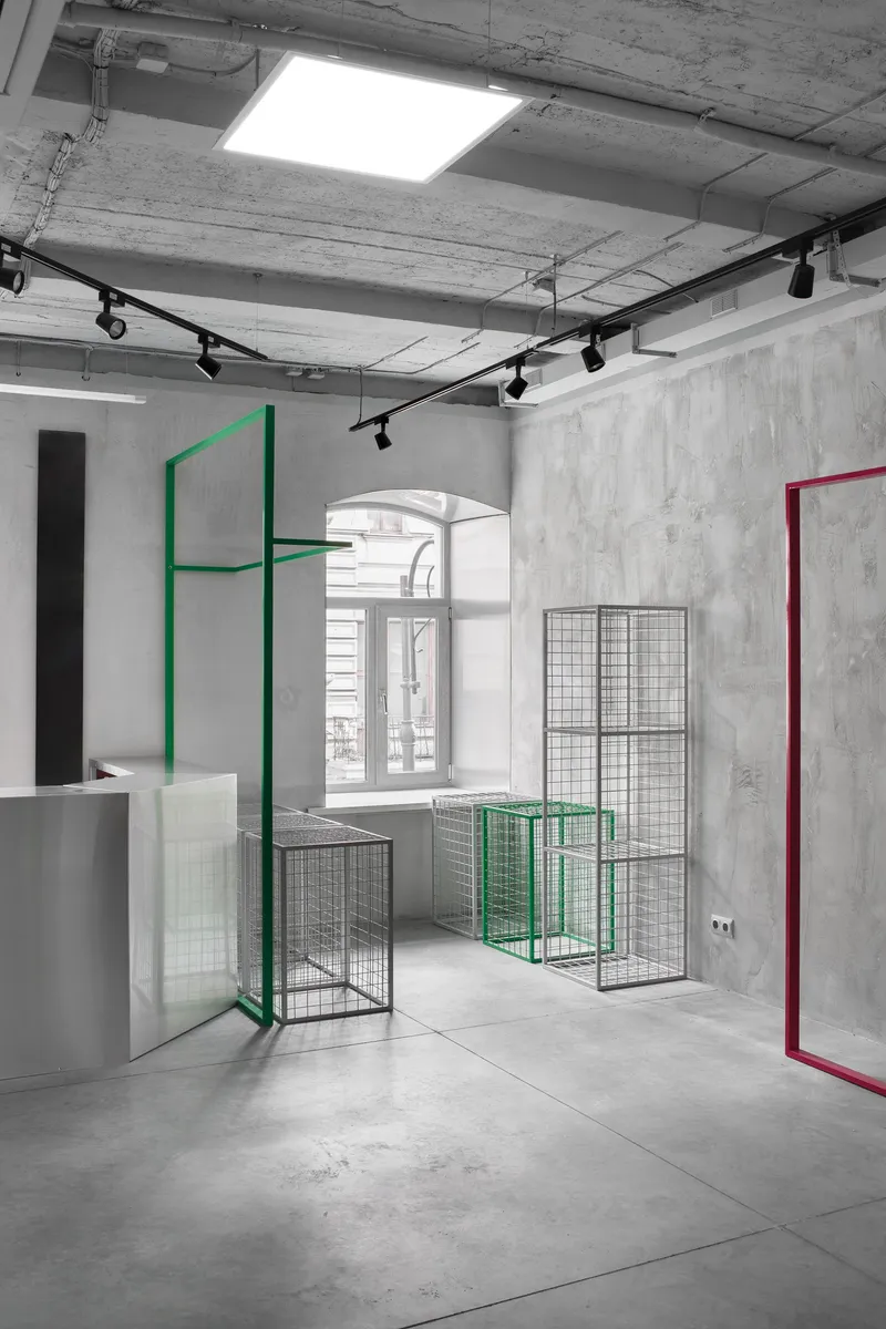 Minimal industrial showroom with modular metal display frames and exposed concrete finishes.