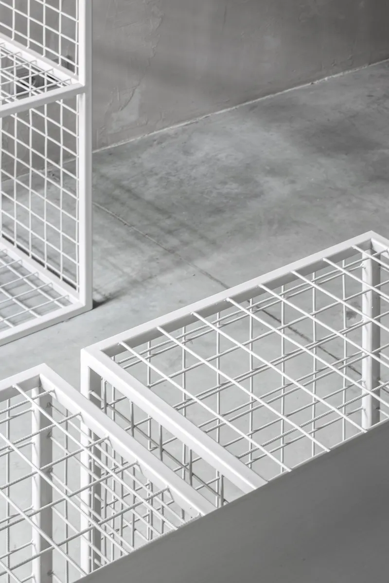 Close-up of white steel grid display units highlighting material precision and texture.