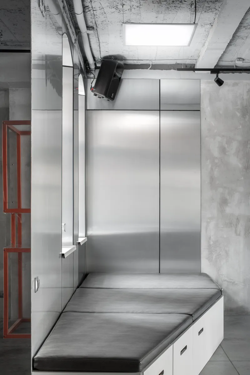 Monochrome interior with integrated seating and concealed storage for multifunctional use.