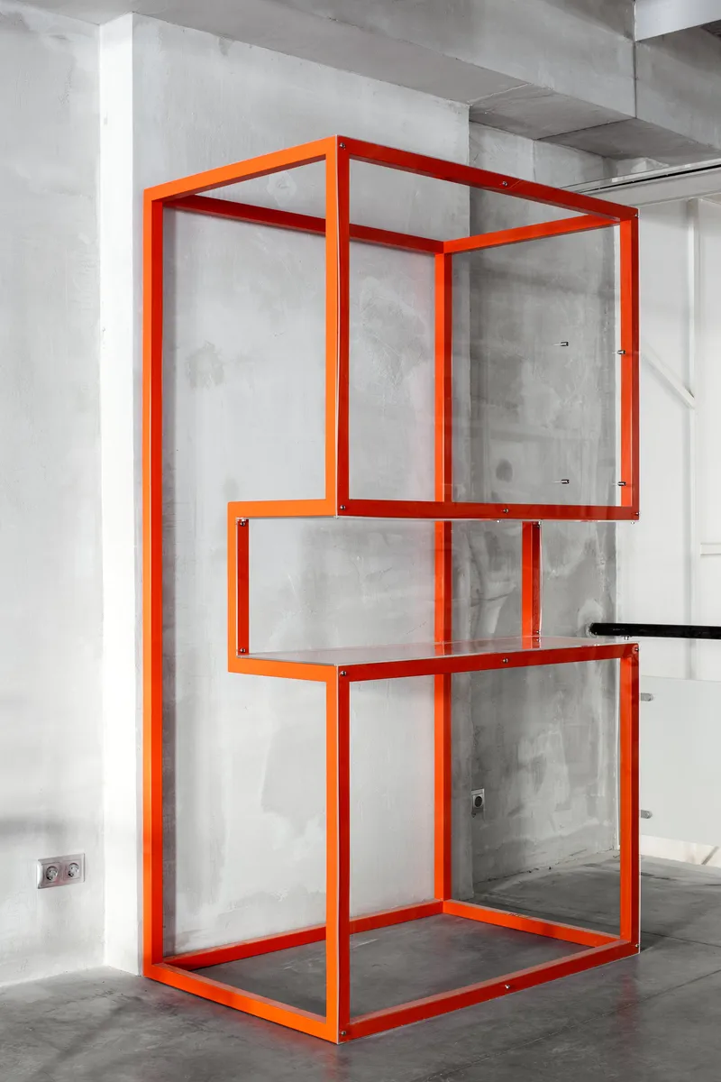 Bright orange modular display structure acting as a sculptural retail element.